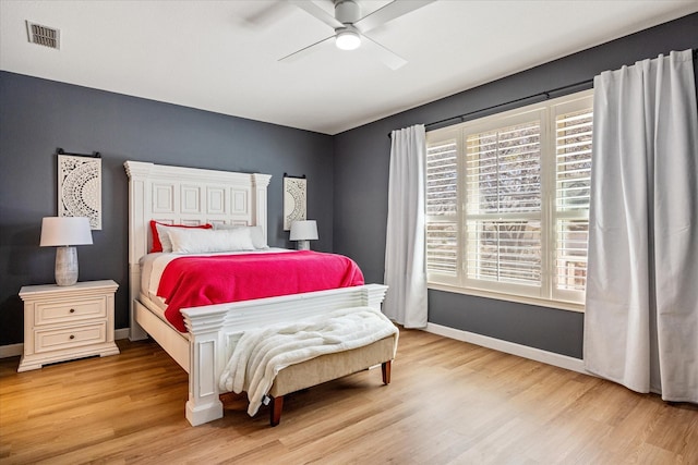 bedroom featuring visible vents, a ceiling fan, baseboards, and wood finished floors