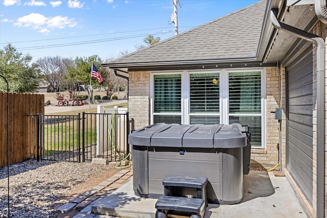 view of patio with fence and a hot tub