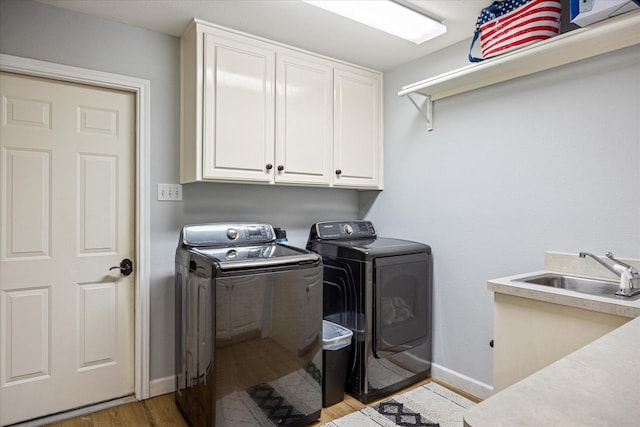4105 Cimmaron Trl, Granbury, TX 76049 - laundry room featuring cabinet space, washing machine and clothes dryer, baseboards, and light wood-style flooring