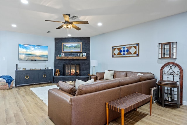 living area with visible vents, recessed lighting, light wood-style flooring, a fireplace, and a ceiling fan