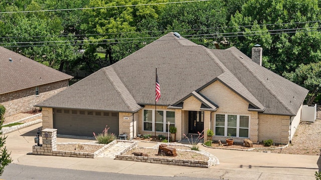 4105 Cimmaron Trl, Granbury, TX 76049 - view of front facade with brick siding, driveway, roof with shingles, a garage, and a chimney