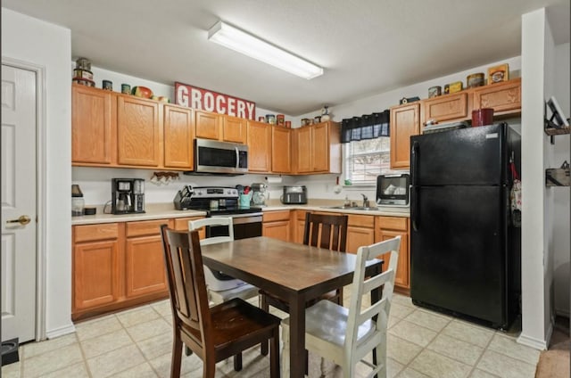 kitchen featuring stainless steel appliances, a sink, and light countertops