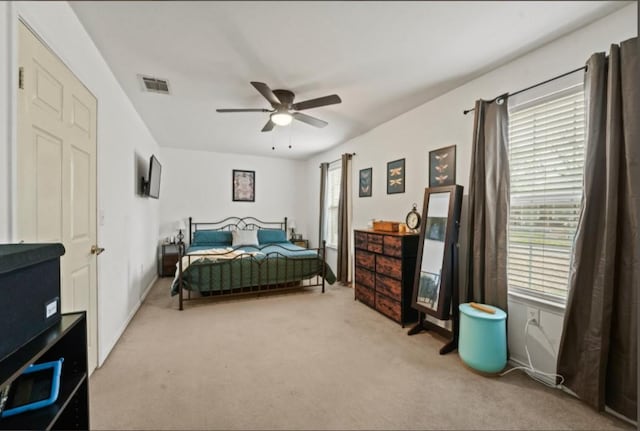 carpeted bedroom featuring ceiling fan and visible vents