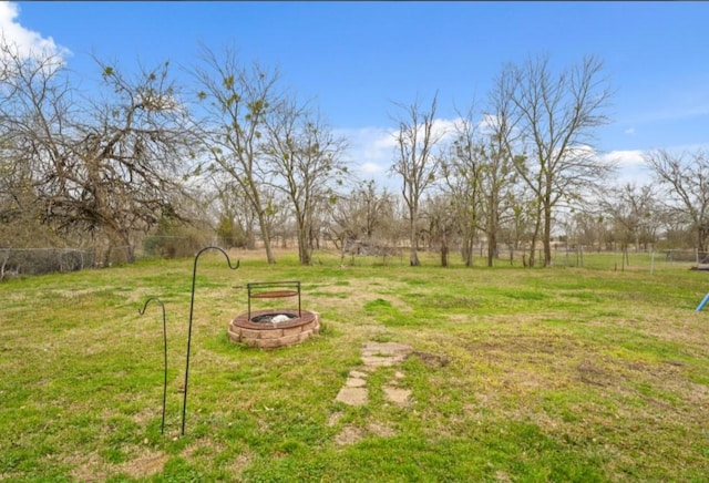 view of yard featuring fence and a fire pit