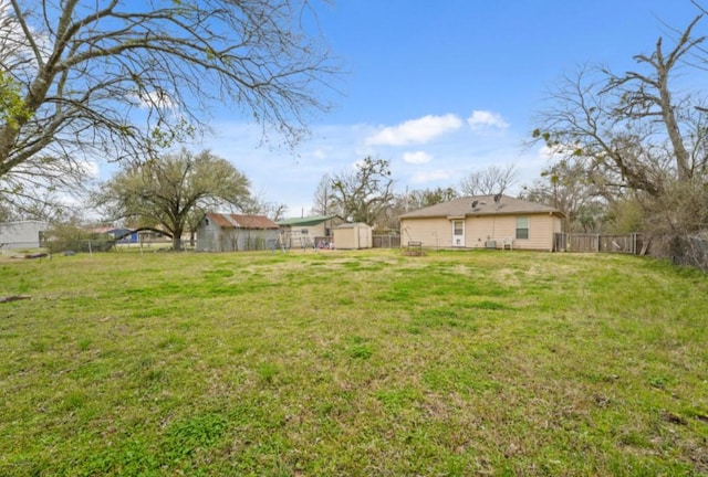 view of yard featuring an outdoor structure and fence