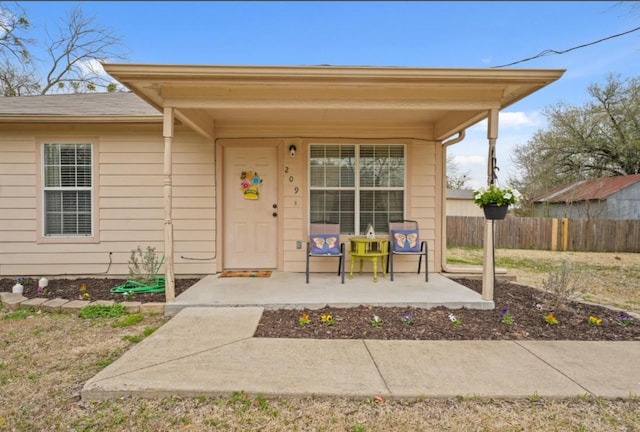 doorway to property featuring fence