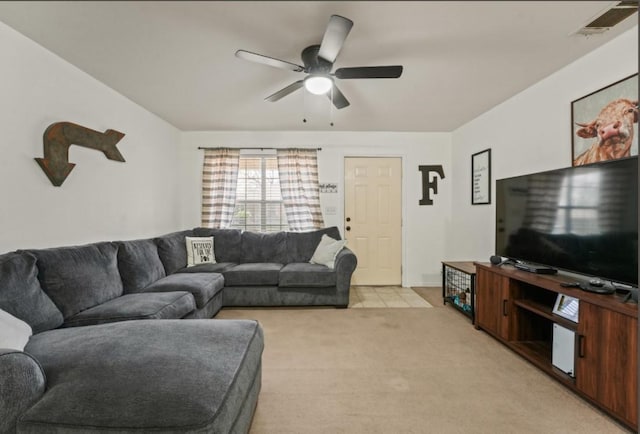 living area with light carpet, visible vents, and a ceiling fan