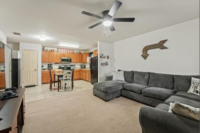 living room with light tile patterned flooring, visible vents, a ceiling fan, and light colored carpet