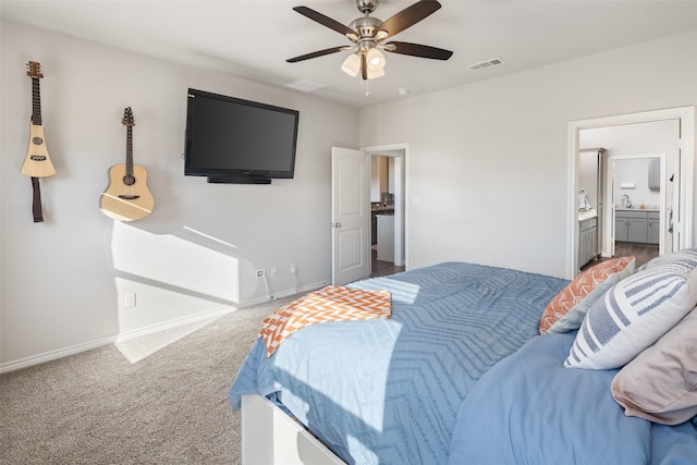 bedroom featuring ensuite bathroom, light colored carpet, a sink, visible vents, and baseboards