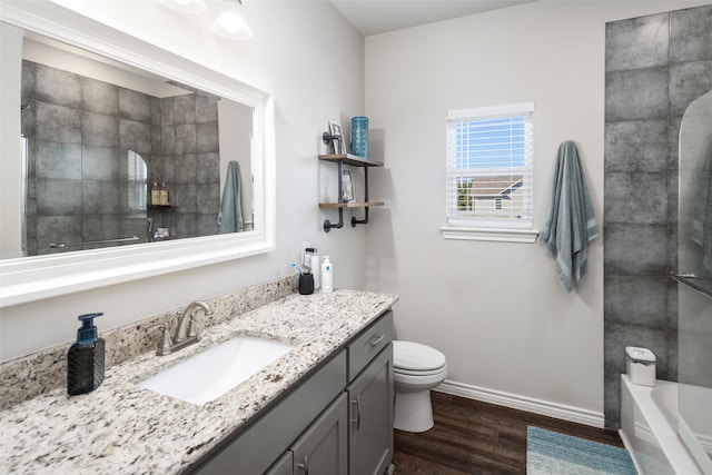 bathroom with baseboards, a shower, wood finished floors, and vanity