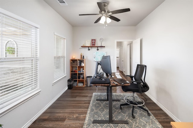 home office with dark wood-style floors, visible vents, baseboards, and a ceiling fan