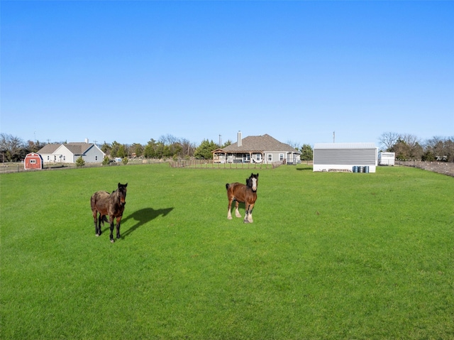 view of yard with an outbuilding and a rural view