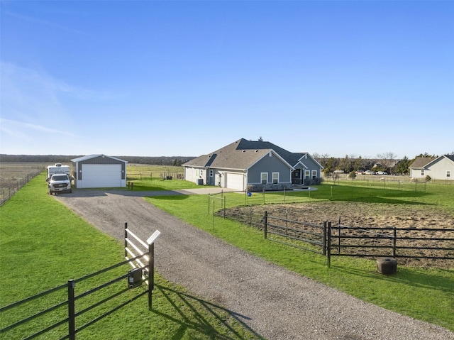 view of home's community featuring a rural view, a yard, driveway, and fence