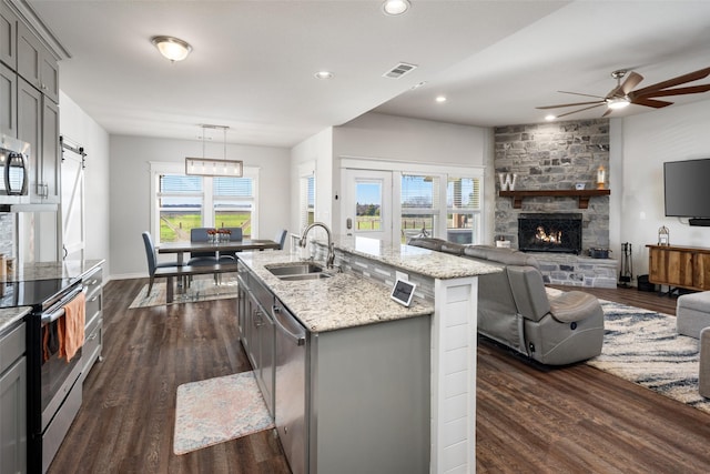 kitchen with stainless steel appliances, gray cabinets, visible vents, dark wood-type flooring, and a sink