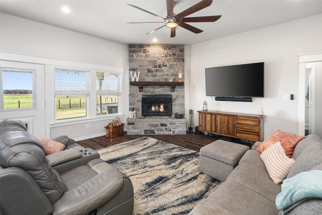 living room with a ceiling fan, recessed lighting, a stone fireplace, and wood finished floors