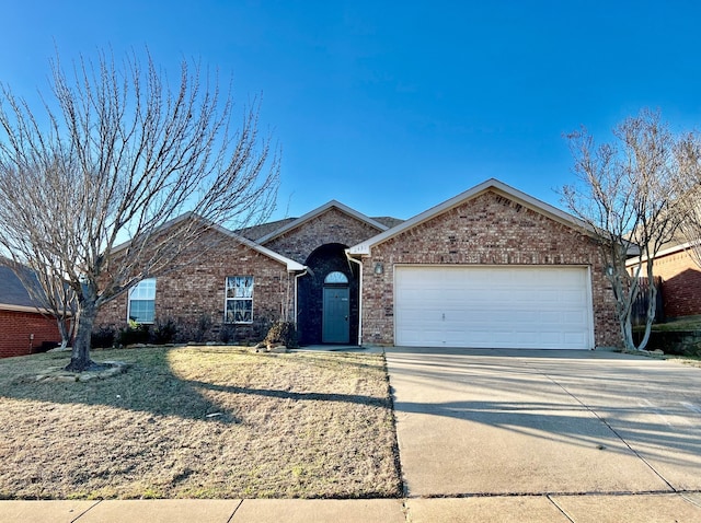 ranch-style home with driveway, brick siding, and an attached garage