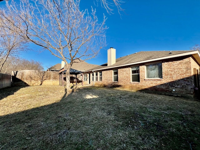2436 Castle Pines Dr, Burleson, TX 76028 - back of house featuring a yard, brick siding, a chimney, and a fenced backyard