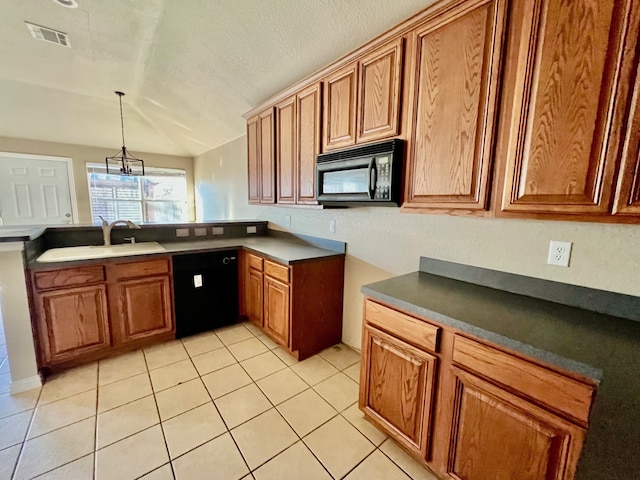 kitchen featuring brown cabinetry, visible vents, a sink, and black appliances