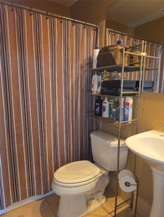 full bath with tile patterned flooring, toilet, and a sink