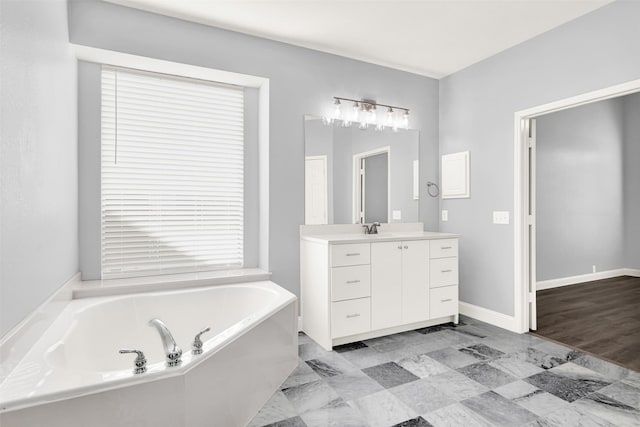 full bathroom with vanity, a bath, and baseboards