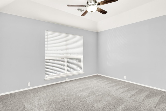 carpeted spare room with baseboards, visible vents, and a ceiling fan