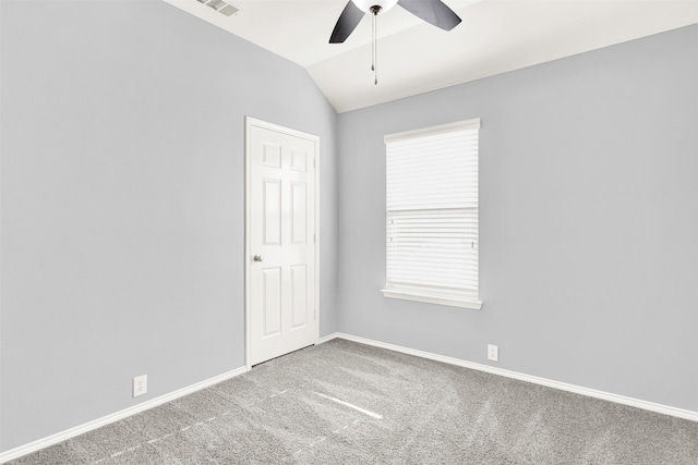 carpeted empty room with lofted ceiling, visible vents, ceiling fan, and baseboards