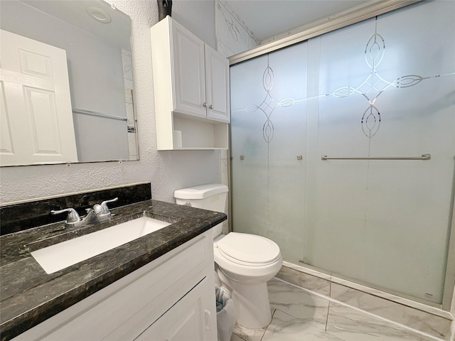 full bath featuring marble finish floor, a stall shower, vanity, and toilet