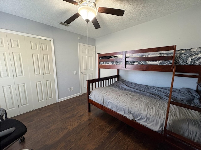 bedroom with a closet, visible vents, a ceiling fan, a textured ceiling, and wood finished floors