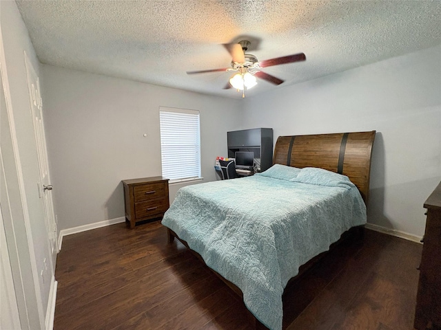 bedroom featuring ceiling fan, dark wood-style flooring, a textured ceiling, and baseboards