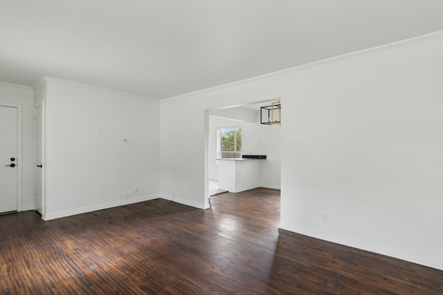 unfurnished room featuring ornamental molding, baseboards, and wood finished floors