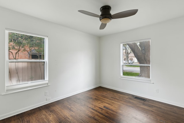 empty room featuring visible vents, a ceiling fan, baseboards, and wood finished floors