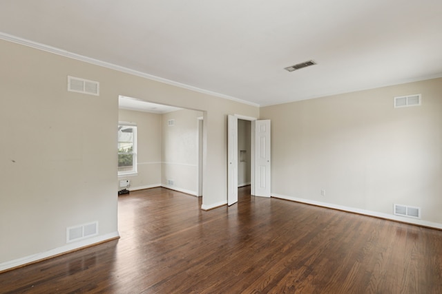 unfurnished room with dark wood-style floors and visible vents