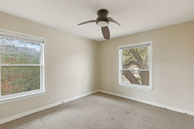 carpeted spare room with ceiling fan and baseboards