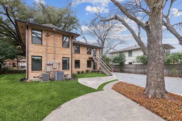 view of property's community with stairway, a lawn, and fence