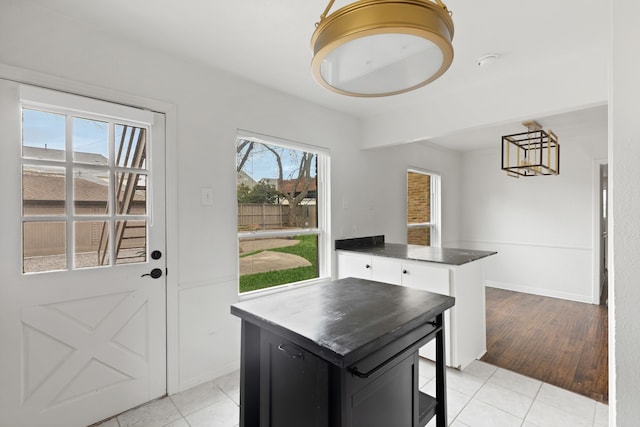 doorway to outside with baseboards and light tile patterned flooring