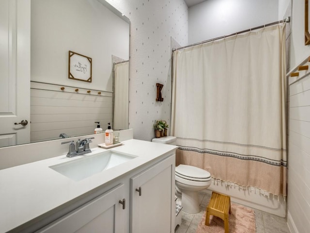 full bath with toilet, vanity, tile patterned floors, wallpapered walls, and shower / bathtub combination with curtain