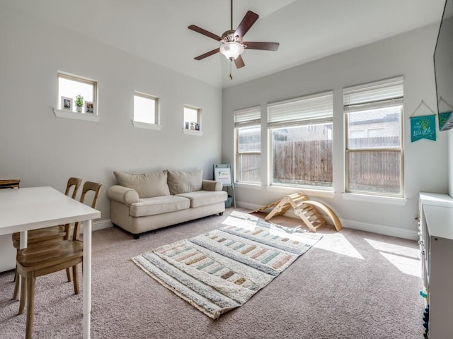 carpeted living room featuring ceiling fan and baseboards