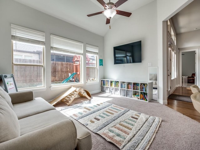 carpeted living room featuring vaulted ceiling, ceiling fan, and baseboards