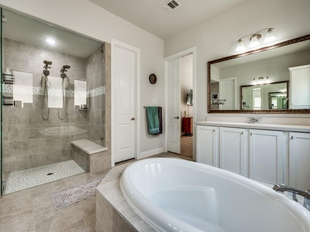 bathroom with visible vents, vanity, baseboards, a tile shower, and a bath