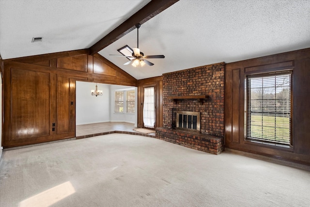 unfurnished living room with plenty of natural light, a brick fireplace, visible vents, carpet, and wood walls