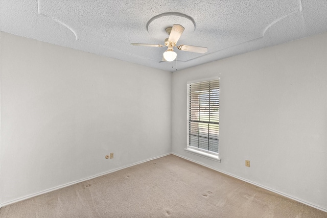 unfurnished room with ceiling fan, a textured ceiling, baseboards, and carpet flooring