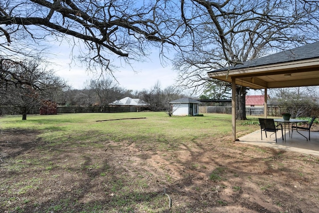 view of yard featuring an outbuilding, a storage shed, a patio area, and a fenced backyard