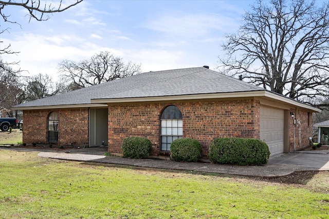 view of front of home featuring a shingled roof, concrete driveway, an attached garage, a front lawn, and brick siding