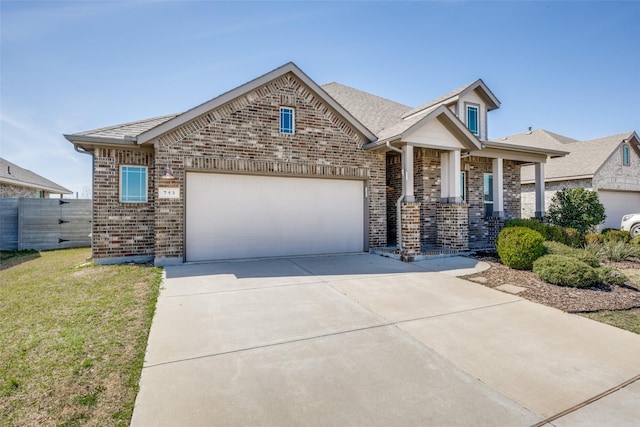 view of front of house with a front yard, brick siding, driveway, and an attached garage