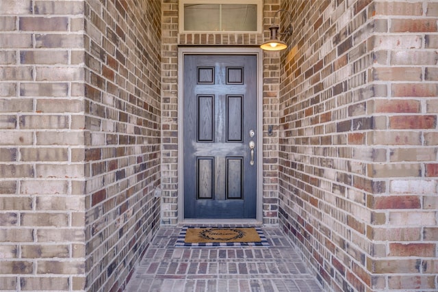 doorway to property with brick siding