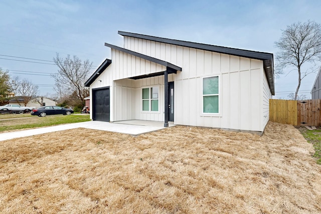 view of front of property with board and batten siding, a patio area, and fence