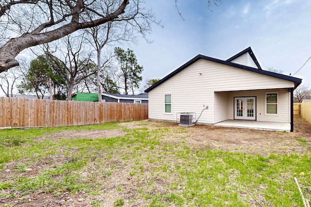 rear view of house featuring cooling unit, french doors, a fenced backyard, and a patio area