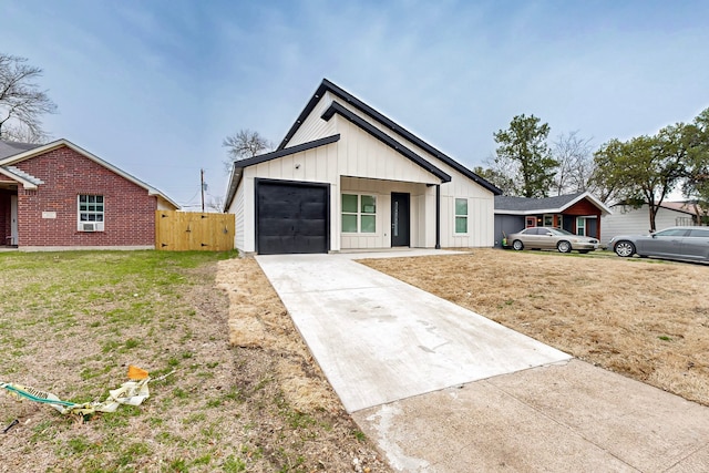 modern farmhouse featuring an attached garage, concrete driveway, board and batten siding, and a front yard