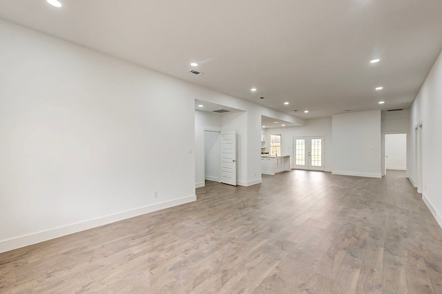 unfurnished living room with french doors, recessed lighting, visible vents, and light wood-style floors