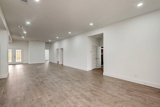 spare room featuring recessed lighting, baseboards, wood finished floors, and french doors